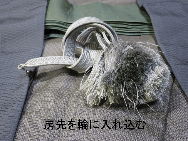 男性用羽織紐の房を輪に入れる